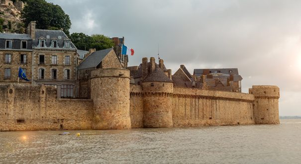 The famous Mont Saint-Michel Abbey at sunrise at high tide in the Manche department, Normandy region, France