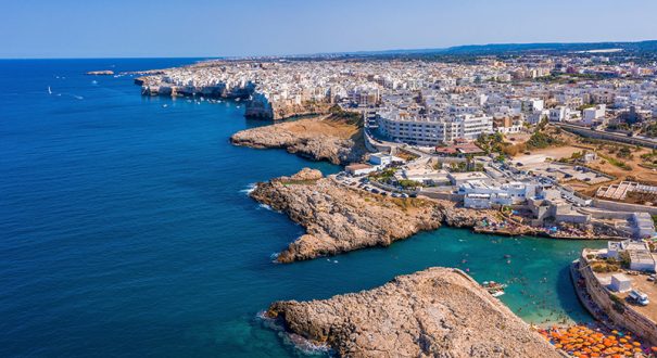 Panoramic shot of Polignano a Mare surrounded by the sea under the sunlight in Italy